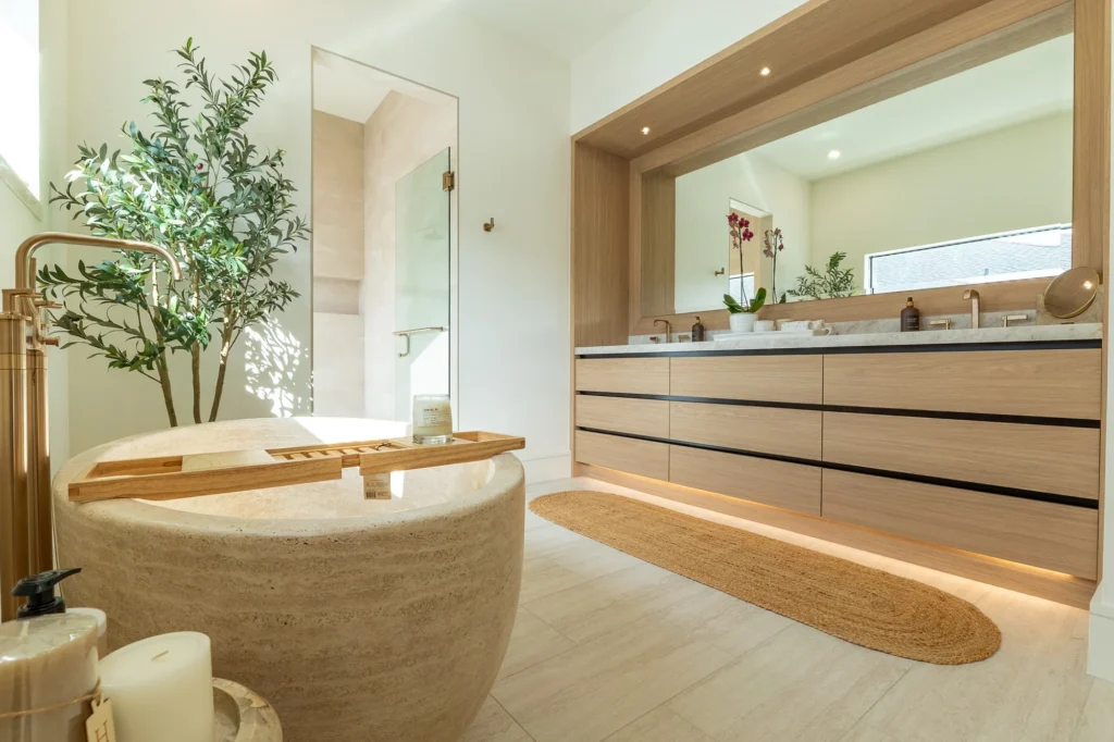 Mill Run primary bathroom with a stone tub, wood vanity and brass fixtures