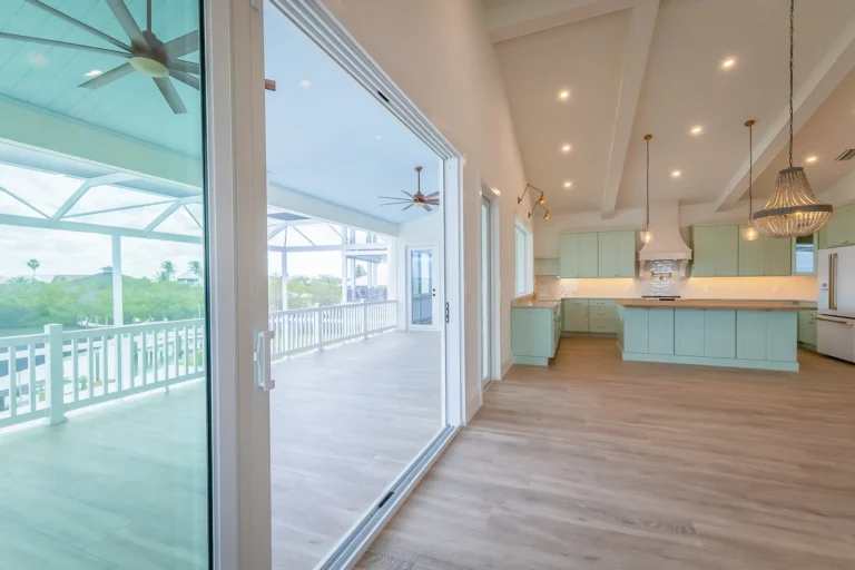 Seminole Way seafoam kitchen opening onto a covered waterfront lanai