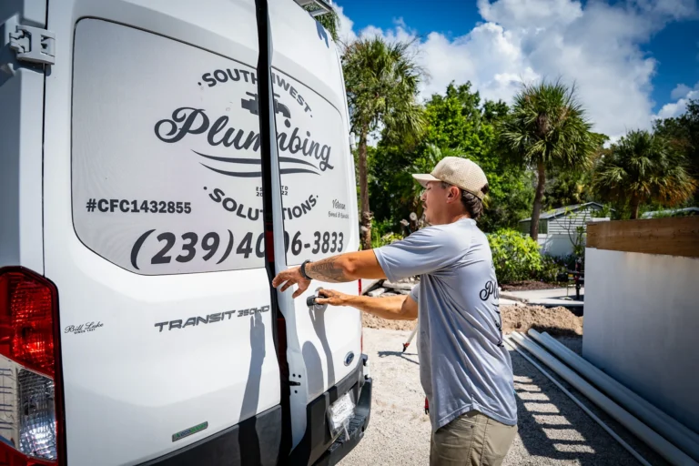 Southwest Plumbing Solutions crew member beside a branded van at an Englewood home construction site